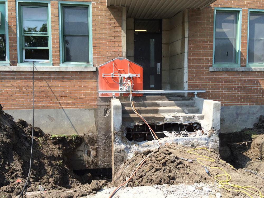 Démolition de mur en béton armé avec excavatrice robotisée à Montréal